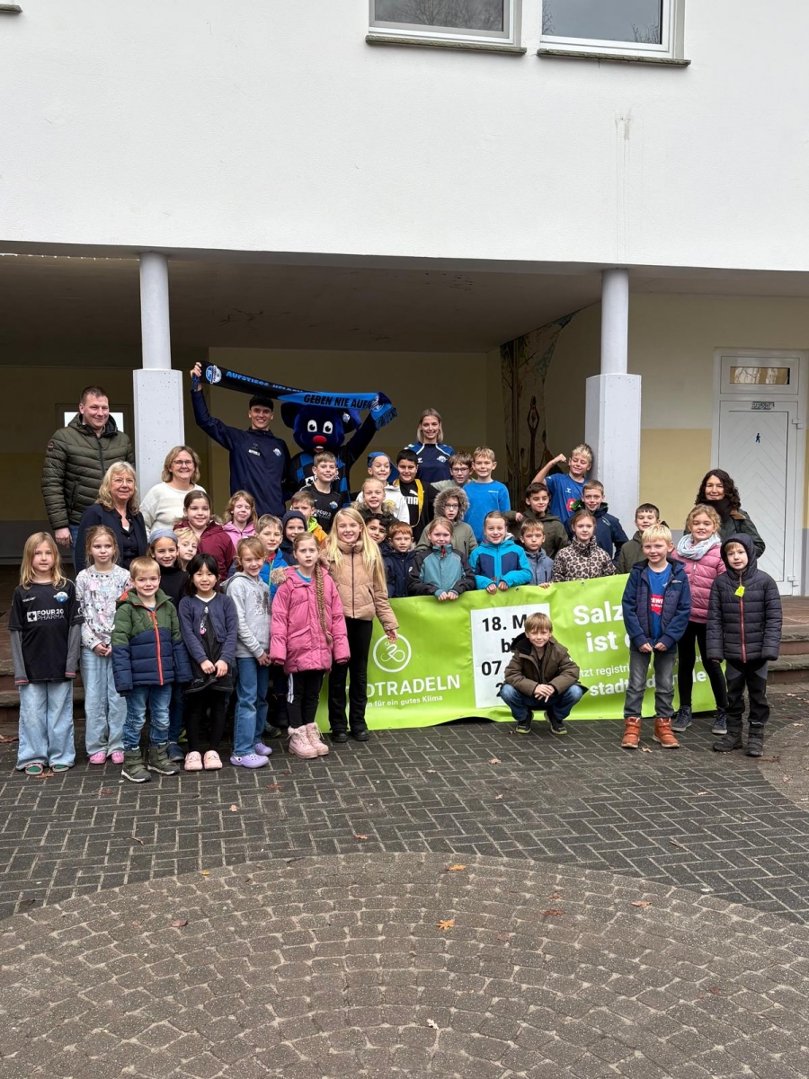 Florian Dickgreber (Amt für Wirtschaft & Tourismus des Kreises Paderborn), Marco Wörner, Maskottchen Holli und Chiara Dreßler (SC Paderborn 07), Inge Adrian (Stadt Salzkotten) mit teilnehmenden Schülerinnen und Schülern des Schulstandortes Scharmede, v.l.. © SC Paderborn 07,  Chiara Dressler